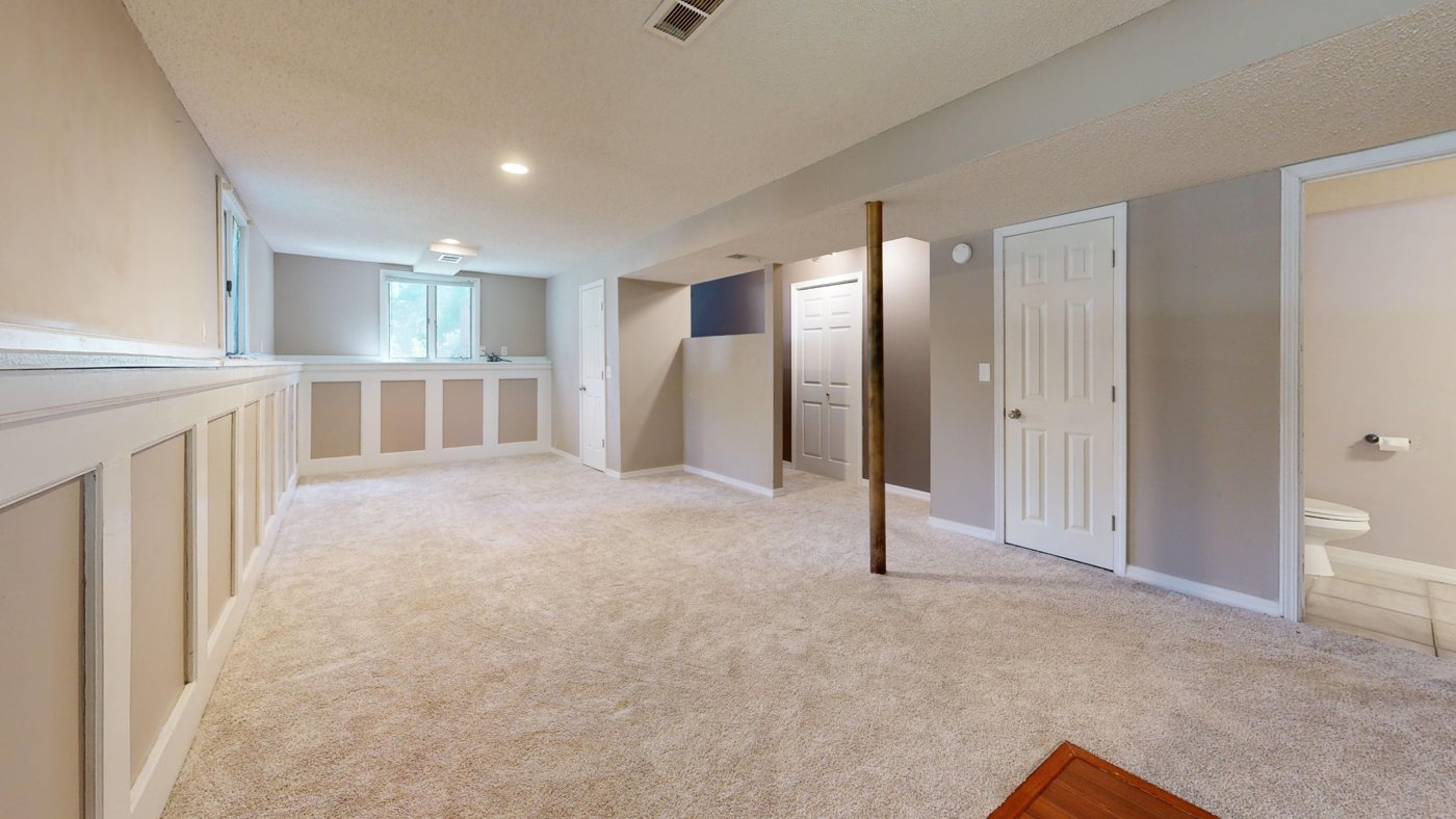 Finished basement with new carpet, wainscoting and recessed lighting